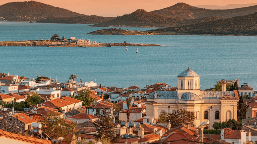 A coastal town with a large body of water and mountains in the background.